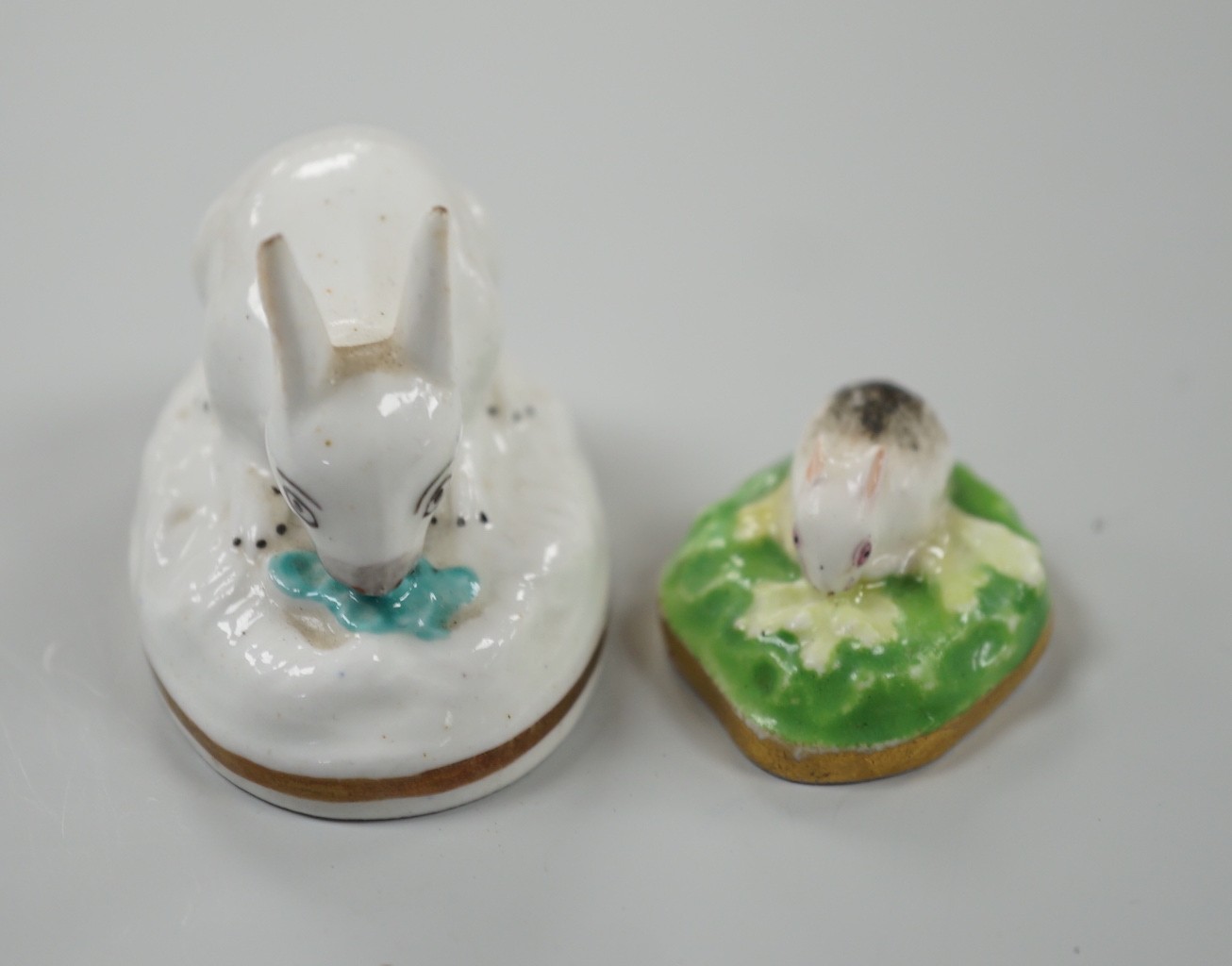 Two toy Staffordshire models of a recumbent rabbit and a bunny, both on oval bases, c.1830-50, (2). Tallest 4cm, Provenance Dennis G.Rice collection